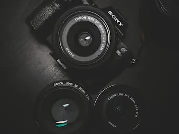 Rechargeable camera battery beside photography equipment